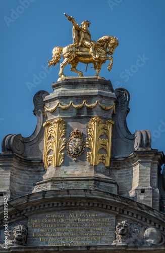 Brussels, Belgium - June 22, 2019: Closeup of gulden statue of Charles Alexander of Lorraine on top of L’Arbre D’Or house on Grand place against blue sky.