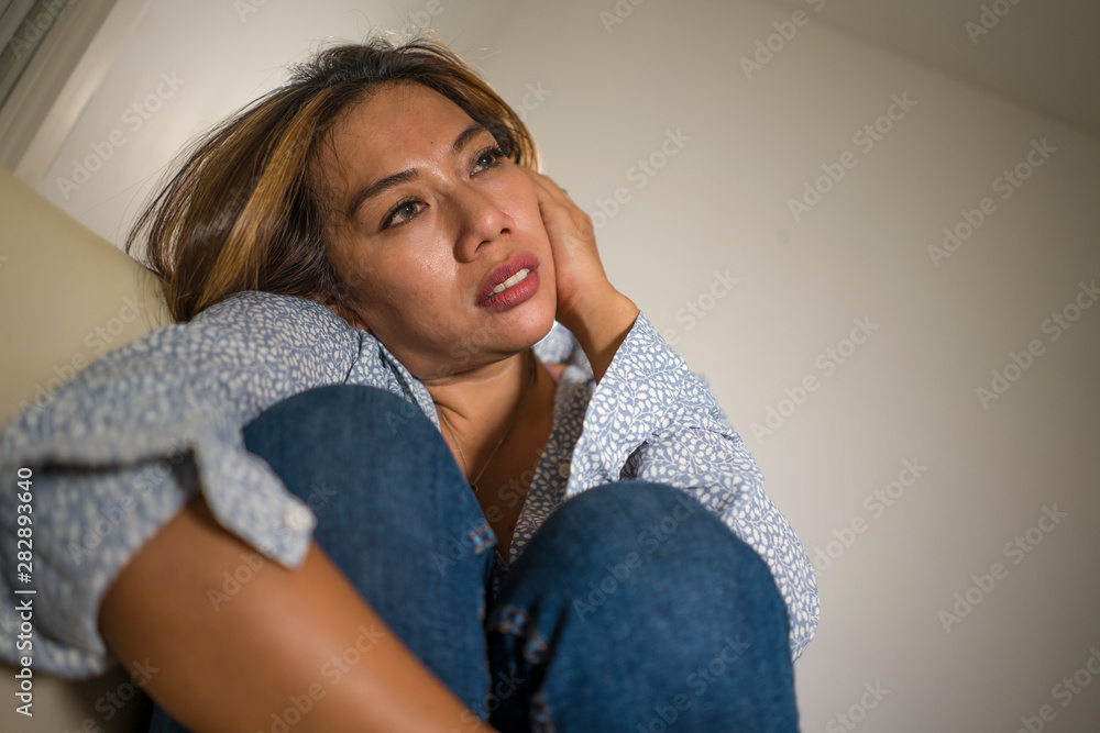 young beautiful sad and depressed woman thoughtful and confused at home couch feeling broken heart suffering depression crisis and anxiety problem young beautiful sad and depressed woman thoughtful and confused at home couch feeling broken heart suffering depression crisis and anxiety problem