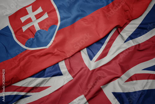 Photography waving colorful flag of great britain and national flag of slovakia