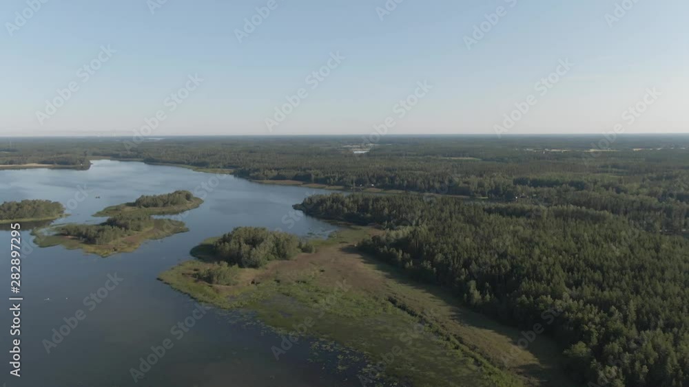 Flying over lake and island. River with ripples. Arial drone shot. Water and waves. Coast and wild forest. Flying over lake and island. River with ripples. Arial drone shot. Water and waves. Coast and wild forest.
