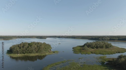 Wallpaper Mural Flying over lake and island. River with ripples. Arial drone shot. Water and waves. Coast and wild forest. Torontodigital.ca