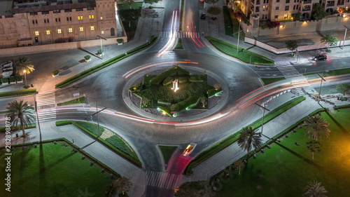 Aerial view of a roundabout circle road in Dubai downtown from above night timelapse. Dubai, United Arab Emirates. © neiezhmakov
