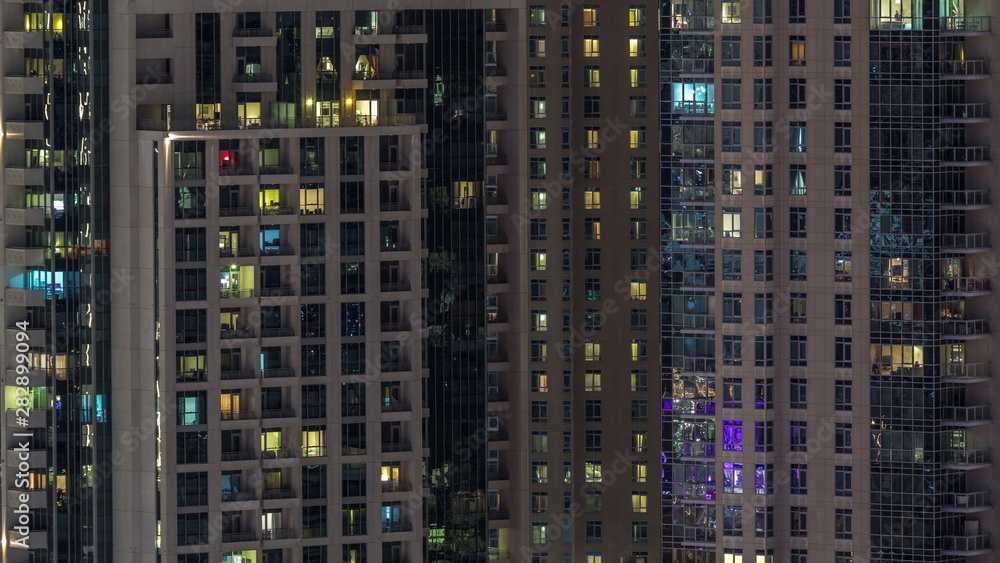 Windows of the multi-storey building with lighting inside and moving people in apartments timelapse. Windows of the multi-storey building with lighting inside and moving people in apartments timelapse.