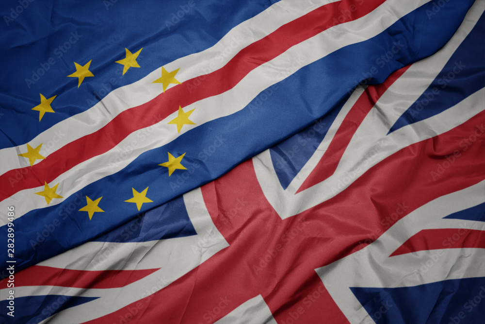 waving colorful flag of great britain and national flag of cape verde. waving colorful flag of great britain and national flag of cape verde.