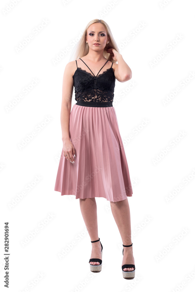 Confident young stylish blonde woman in summer skirt and lace top touching hair looking at camera. Full body isolated on white background. 