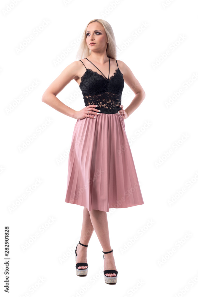 Elegant beautiful blonde fashion model in summer stylish clothes looking up with hands on hips.Full body isolated on white background. 