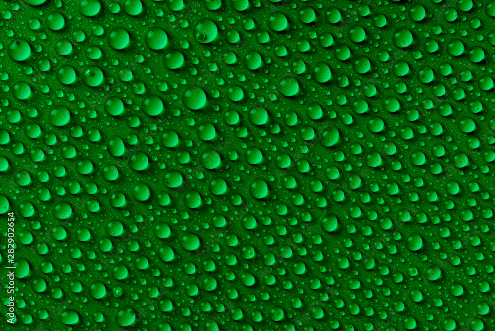 Water drop pattern on a green paper background close-up. The concept of freshness, nature, dew, after rain Water drop pattern on a green paper background close-up. The concept of freshness, nature, dew, after rain