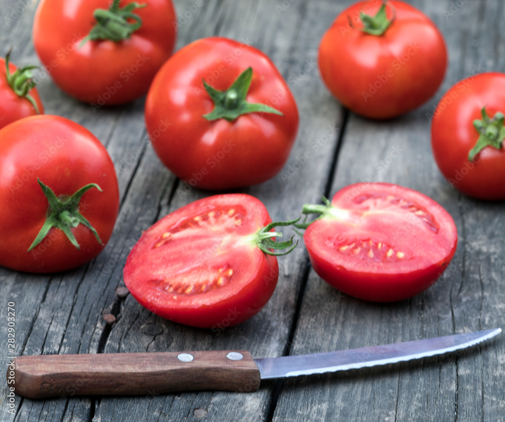 .tomatoes and knife on a wooden background .tomatoes and knife on a wooden background