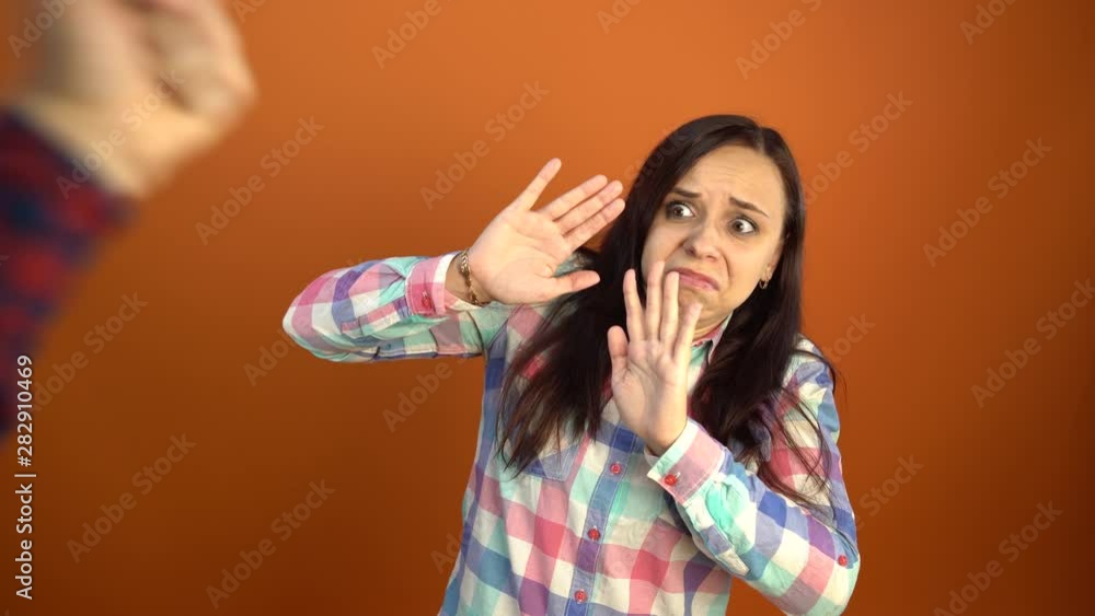 A man threatens a woman with his fist. A man's fist in front of his face. Interpersonal conflicts and domestic violence. A man threatens a woman with his fist. A man's fist in front of his face. Interpersonal conflicts and domestic violence.