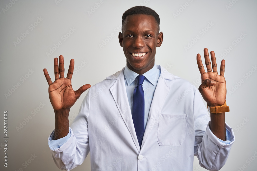 Young african american doctor man wearing coat standing over isolated white background showing and pointing up with fingers number nine while smiling confident and happy. Young african american doctor man wearing coat standing over isolated white background showing and pointing up with fingers number nine while smiling confident and happy.