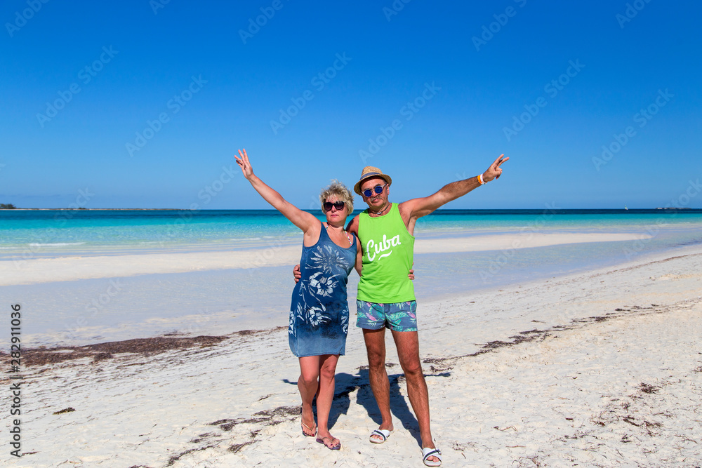 A man and a woman stand embracing on the beach against the backdrop of a beautiful ocean. Horizontally. A man and a woman stand embracing on the beach against the backdrop of a beautiful ocean. Horizontally.