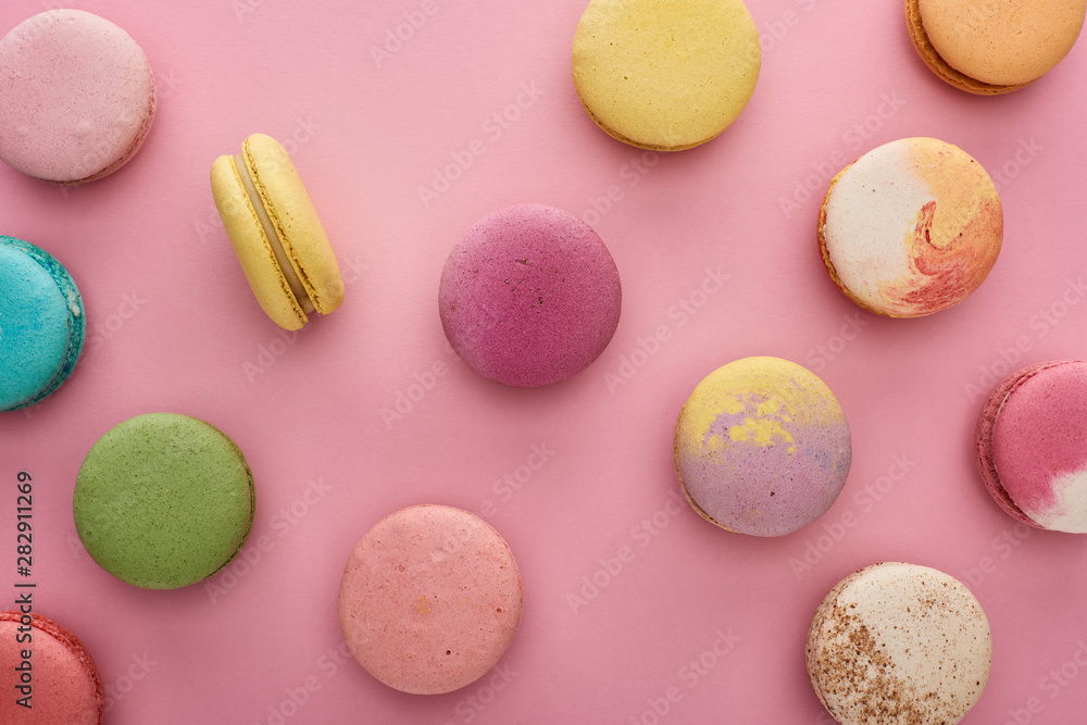 Fototapeta premium pattern of multicolored tasty French macaroons scattered on pink background