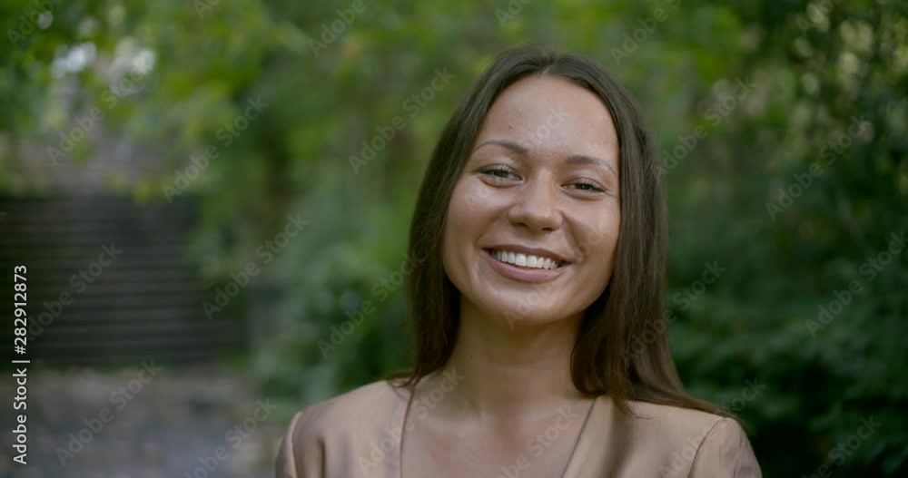 portrait of a charming Asian woman in a green Park. dressed in a strict business suit portrait of a charming Asian woman in a green Park. dressed in a strict business suit