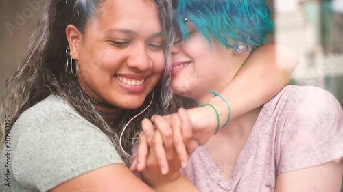 Lesbian teen couple kissing in a public place. Not embarrassed of their sexuality. Proud to be gay. Tender gay couple showing affection and love. Right to be free and happy.