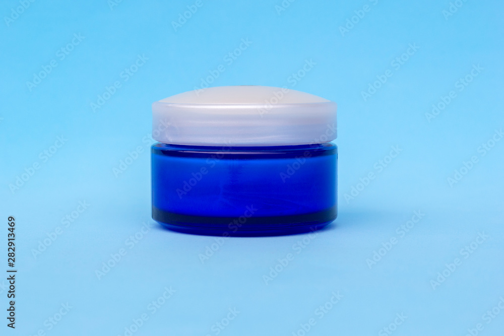 Blank blue cream jar on light background. Cosmetic skincare products, modern concept of organic beauty trend. Blank blue cream jar on light background. Cosmetic skincare products, modern concept of organic beauty trend.