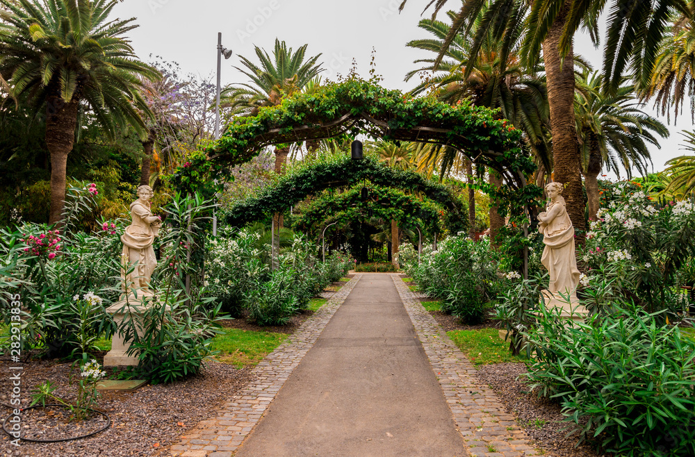 A walkpath through scenic garden with sculptures on the sides in Garcia Sanabria park, Santa Cruz de Tenerife, Canary Islands, Spain