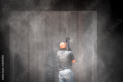 Foto A man sandblashes metal under high pressure. Slow motion
