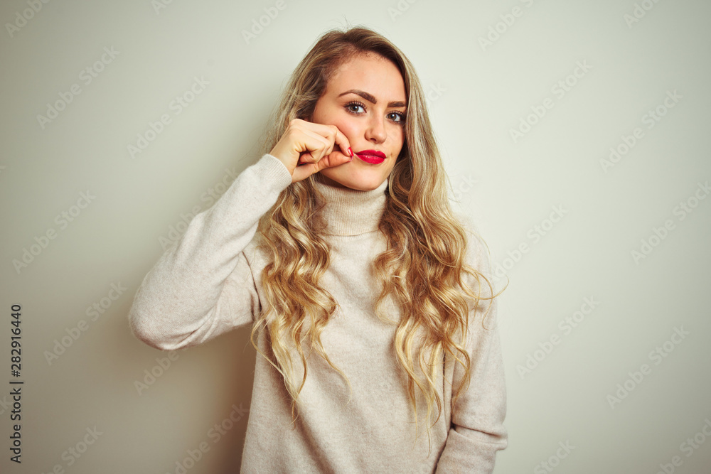 Beautiful woman wearing winter turtleneck sweater over isolated white background mouth and lips shut as zip with fingers. Secret and silent, taboo talking Beautiful woman wearing winter turtleneck sweater over isolated white background mouth and lips shut as zip with fingers. Secret and silent, taboo talking