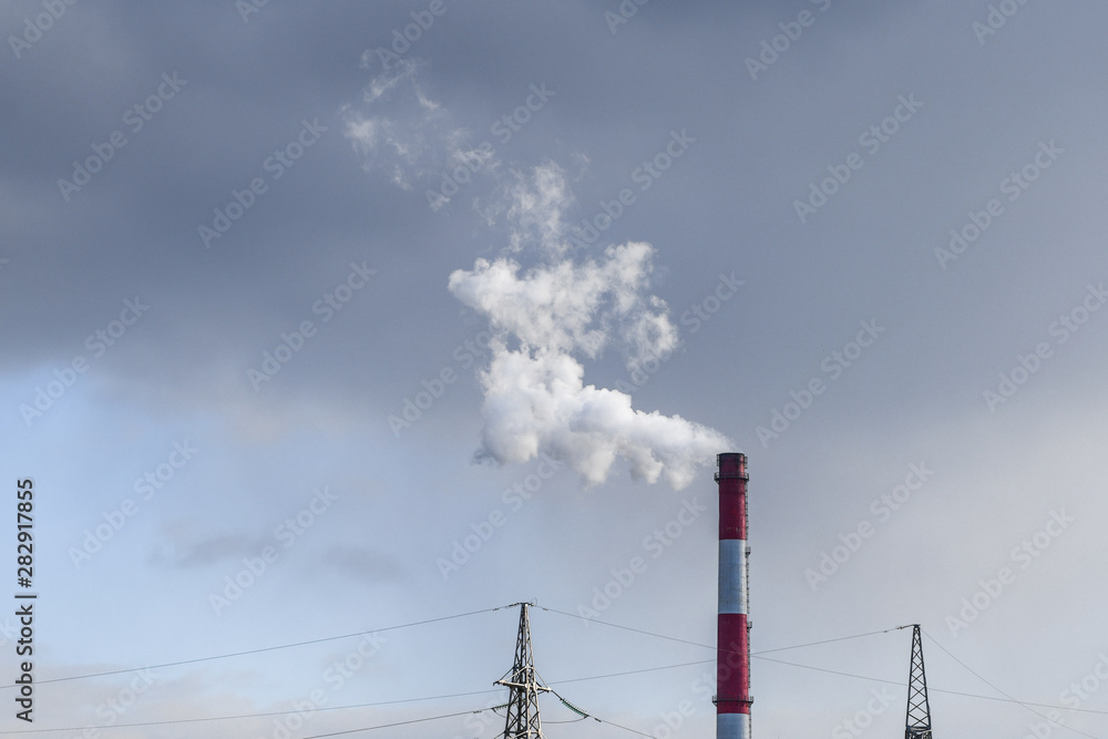 Harmful evaporation from a pipe. Factory chimney with white smoke and contaminated sky