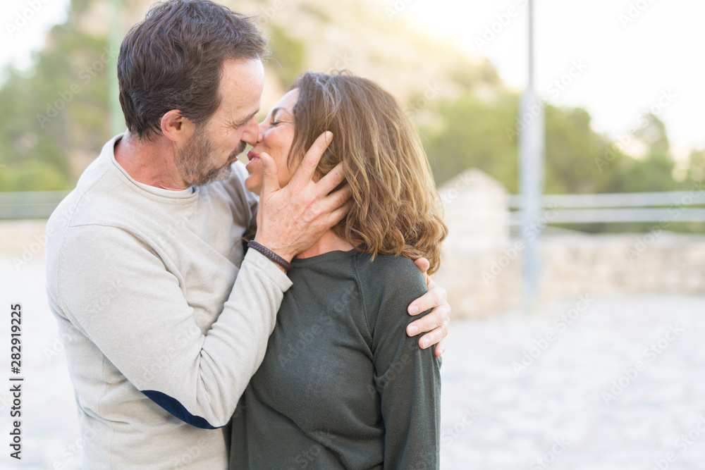 Fototapeta premium Romantic couple smiling and cuddling kissing in love on a sunny day