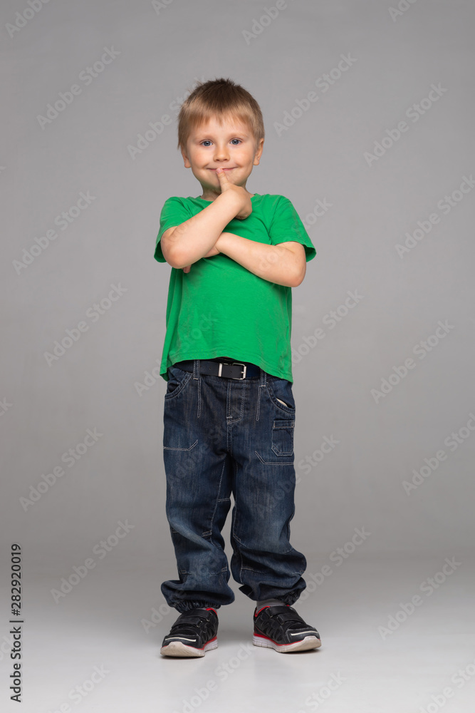 Portrait of happy smiling boy in green t-shirt and jeans. Attractive kid in studio. Portrait of happy smiling boy in green t-shirt and jeans. Attractive kid in studio.