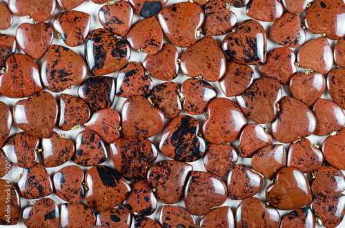 Bulk of mahogany obsidian heart-shaped stones texture background