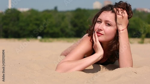 Beautiful brunette girl in a swimsuit, summer on a sandy beach, posing for the camera romantic mood, modern girl, stylish photo