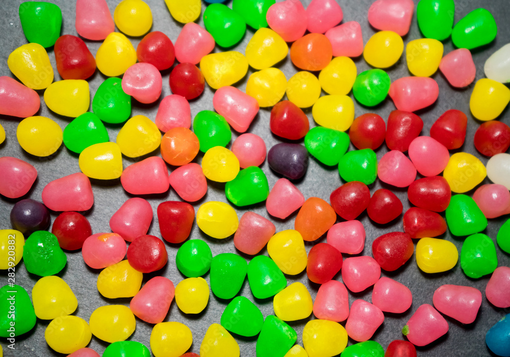 Obraz premium Multicolored gummy fruit in a black background.