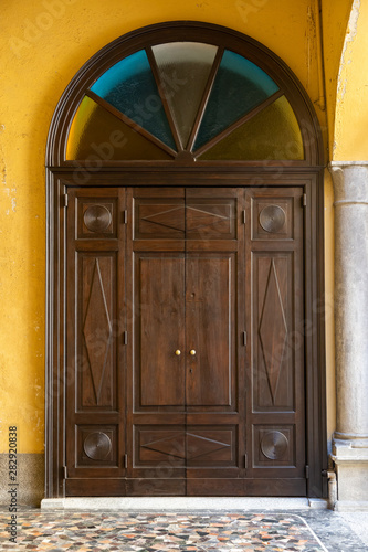 porta in legno a volta con vetrate colorate chiesa italia