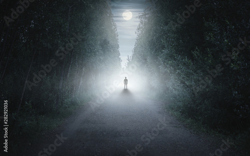 Silhouette of a man in a dark and foggy forest
