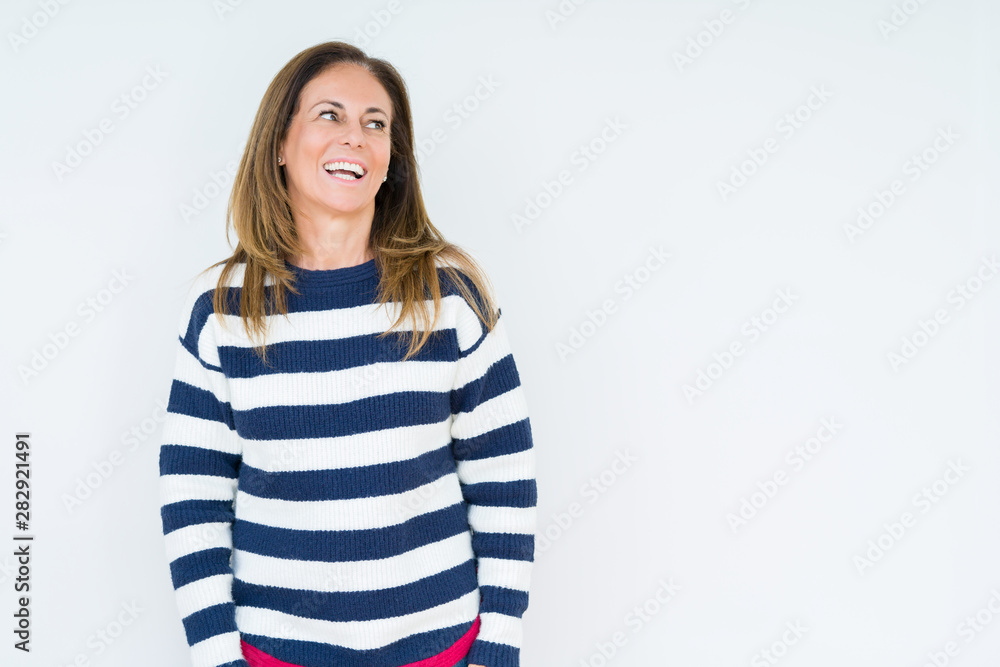 Beautiful middle age woman wearing navy sweater over isolated background looking away to side with smile on face, natural expression. Laughing confident. Beautiful middle age woman wearing navy sweater over isolated background looking away to side with smile on face, natural expression. Laughing confident.