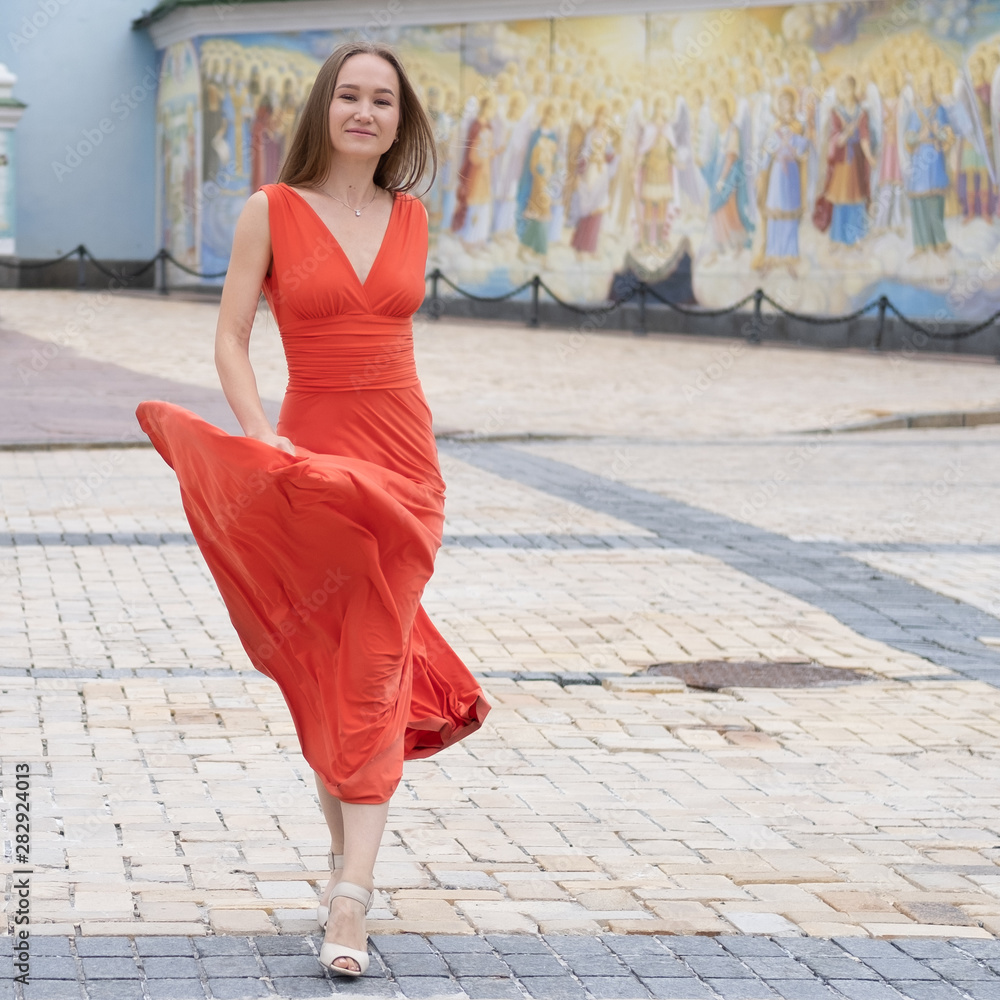 Attractive, Slim, Beautiful Girl Wearing White Shirt And Maxi Long Red Silk Fabric Skirt Fly And Wave In The Wind Walking. Fashion Concept