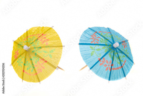 Two colorfull cocktail umbrella   s isolated against white background