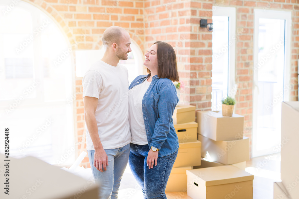 Young couple together smiling happy moving to a new house Young couple together smiling happy moving to a new house