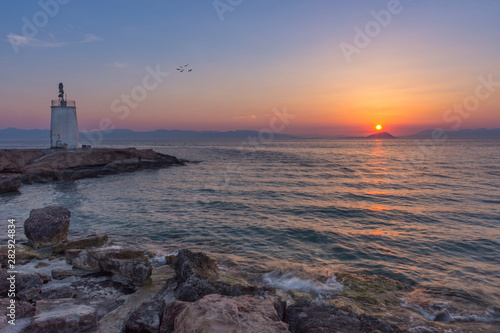 Old small lighthouse of the Aegina island  Saronic gulf  Greece  at sunset.