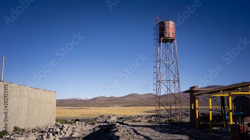 Cisterna depósito de agua oxidado con montañas
