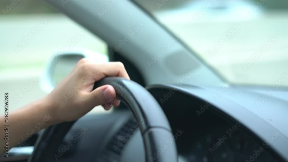 hand of the driver on the car steering wheel while driving on the highway hand of the driver on the car steering wheel while driving on the highway