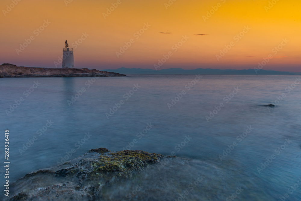 Old small lighthouse of the Aegina island, Saronic gulf, Greece, at sunset.