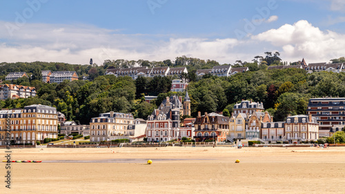 Panoramic view of Trouville coastline with typical norman architecture luxury buildings along the sandy beach. Famous resort and fishermen village in Normandy, France. 