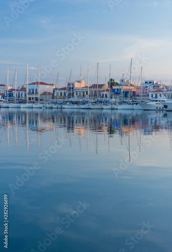 Port of Aegina town with yachts and fishermen boats docked in Aegina island, Saronic gulf, Greece, at sunrise.