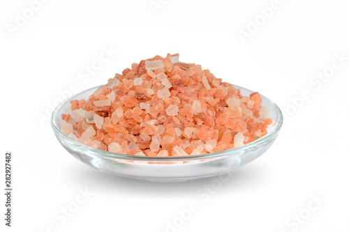Heap of pink himalayan salt in a glass saucer isolated on white background. Himalayan salt is used in cooking, medicine and cosmetology.