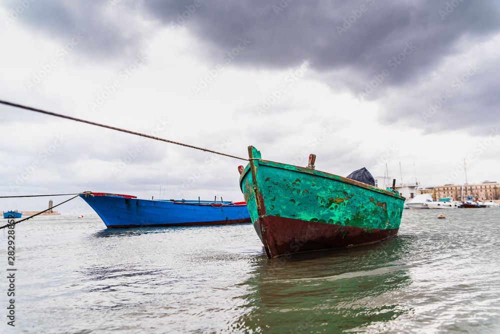 Small boat moored to Bari port, Italy, during a storm at sea. Small boat moored to Bari port, Italy, during a storm at sea.