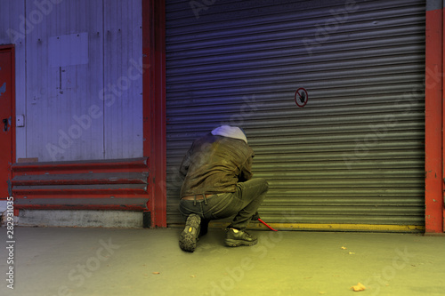 a thief tries to break a gate at a company with a crowbar