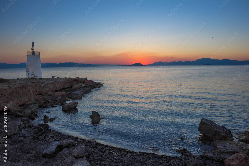 Old small lighthouse of the Aegina island, Saronic gulf, Greece, at sunset.