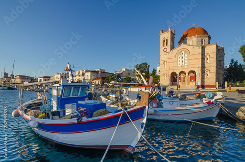 Fototapeta Naklejka Na Ścianę i Meble -  Port of Aegina town with yachts and fishermen boats docked in Aegina island, Saronic gulf, Greece, at sunrise.