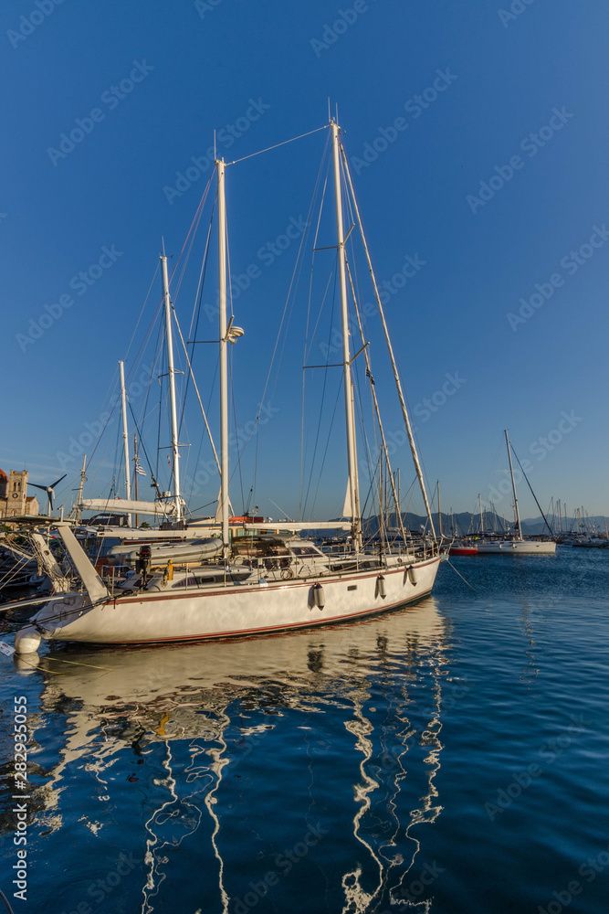 Port of Aegina town with yachts and fishermen boats docked in Aegina island, Saronic gulf, Greece, at sunrise. Port of Aegina town with yachts and fishermen boats docked in Aegina island, Saronic gulf, Greece, at sunrise.