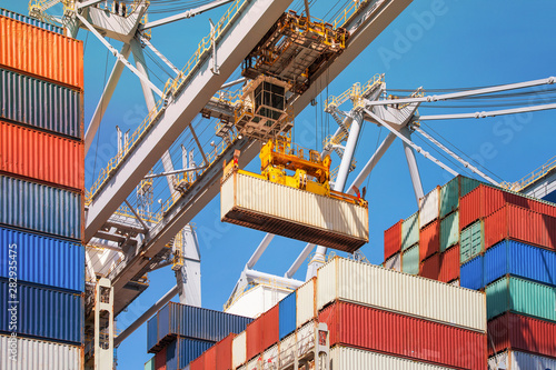 Close-up of how containers are being discharged from a large container ship by a crane in the port of Rotterdam, Europe