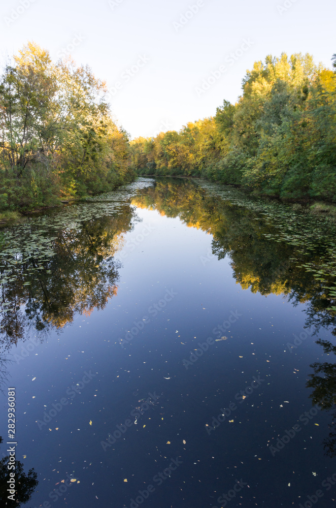 Narrow river channel. River canal in the fall. Narrow river channel. River canal in the fall.