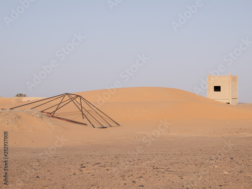 Dunas de areia com estrutura metálica e edifício photo