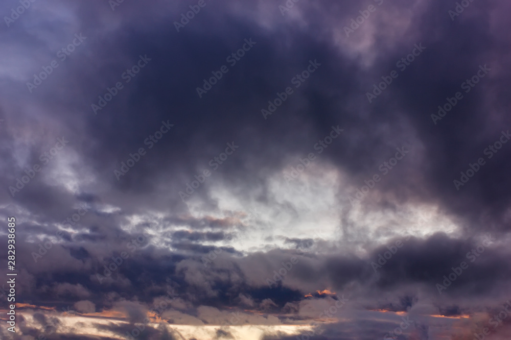 Obraz premium Dark rain clouds during sunset. Dramatic sky during sunset. Dark storm clouds with black and white highlights.